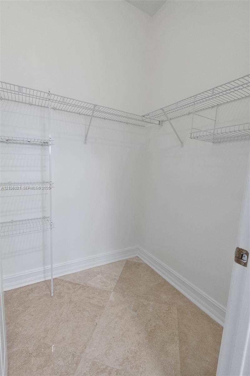19510 S Coquina Way, Weston, FL 33332 Walk-in storage space featuring neutral stone-finish tile flooring and multi-level white wire shelving