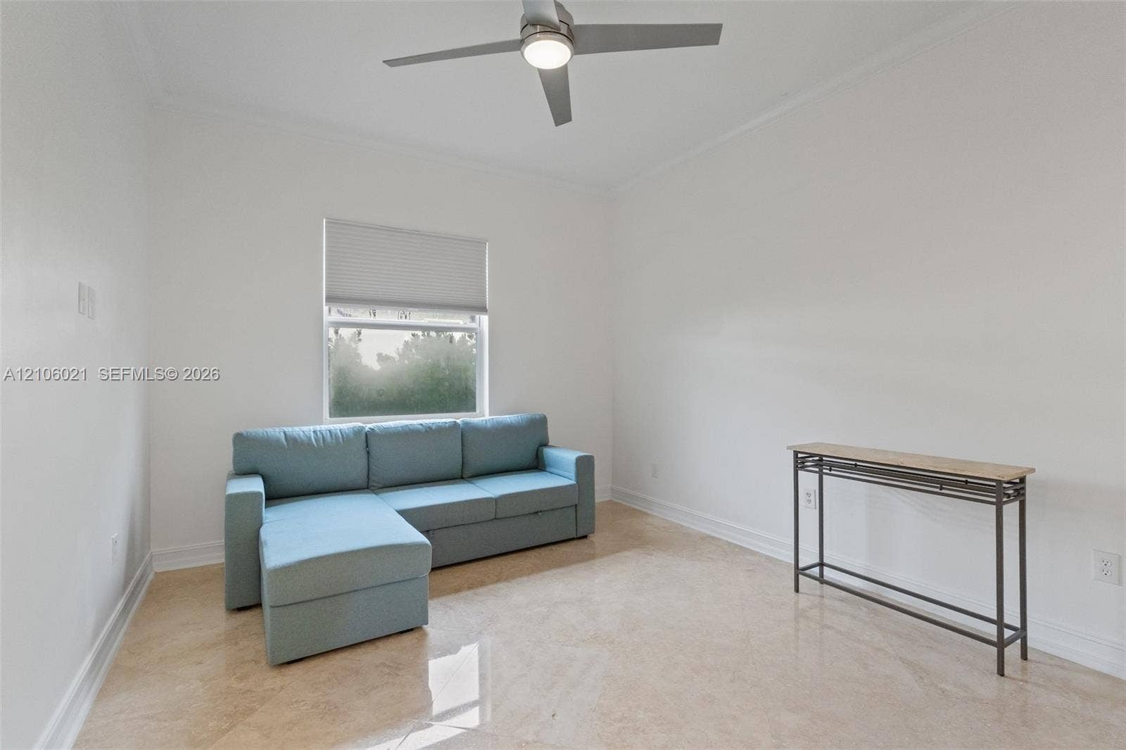 19510 S Coquina Way, Weston, FL 33332 Neutral-toned room featuring large-format tile flooring, a central ceiling fan with an integrated light fixture, and a single window with a cellular shade