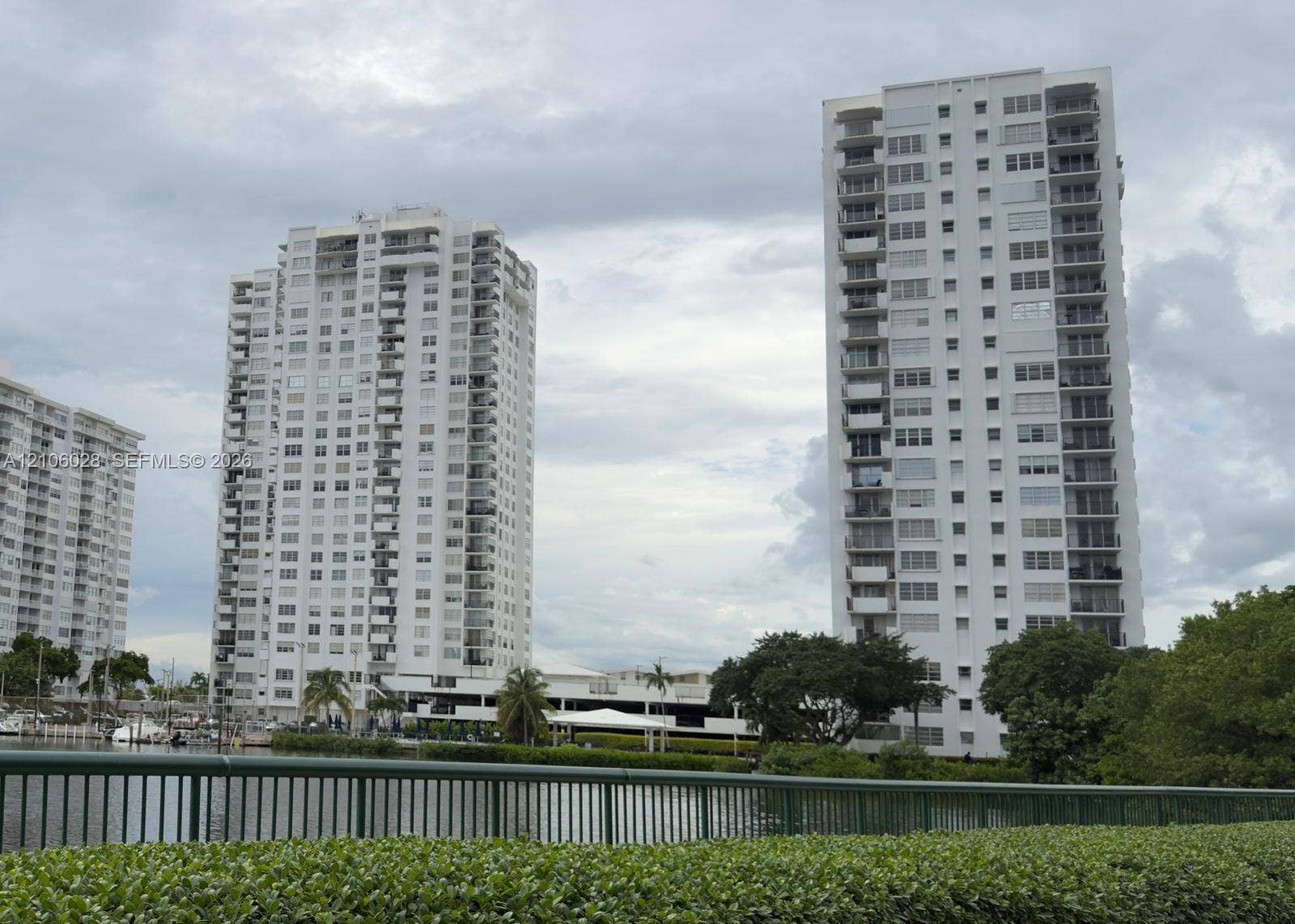 2780 NE 183rd Street, #1605, Aventura, FL 33160 High-rise residential towers featuring multiple private balconies, floor-to-ceiling windows, waterfront positioning, and landscaped perimeter greenery