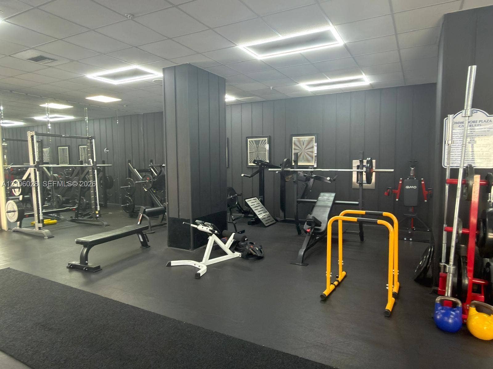 2780 NE 183rd Street, #1605, Aventura, FL 33160 Fitness center featuring wall-to-wall mirrors, vertical panel wall cladding, and rubberized flooring