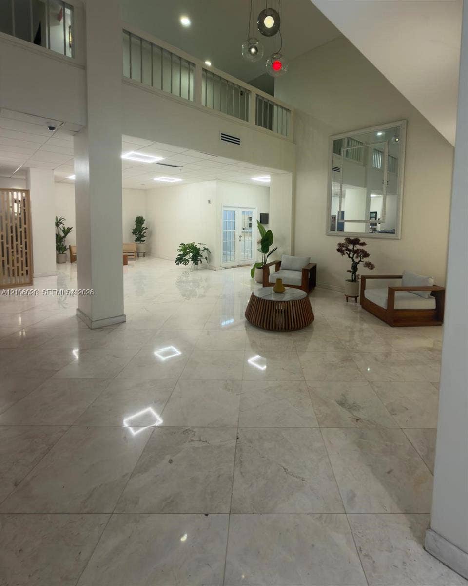 2780 NE 183rd Street, #1605, Aventura, FL 33160 Expansive foyer featuring polished stone flooring, vaulted ceilings, a structural support column, and a railed upper-level balcony