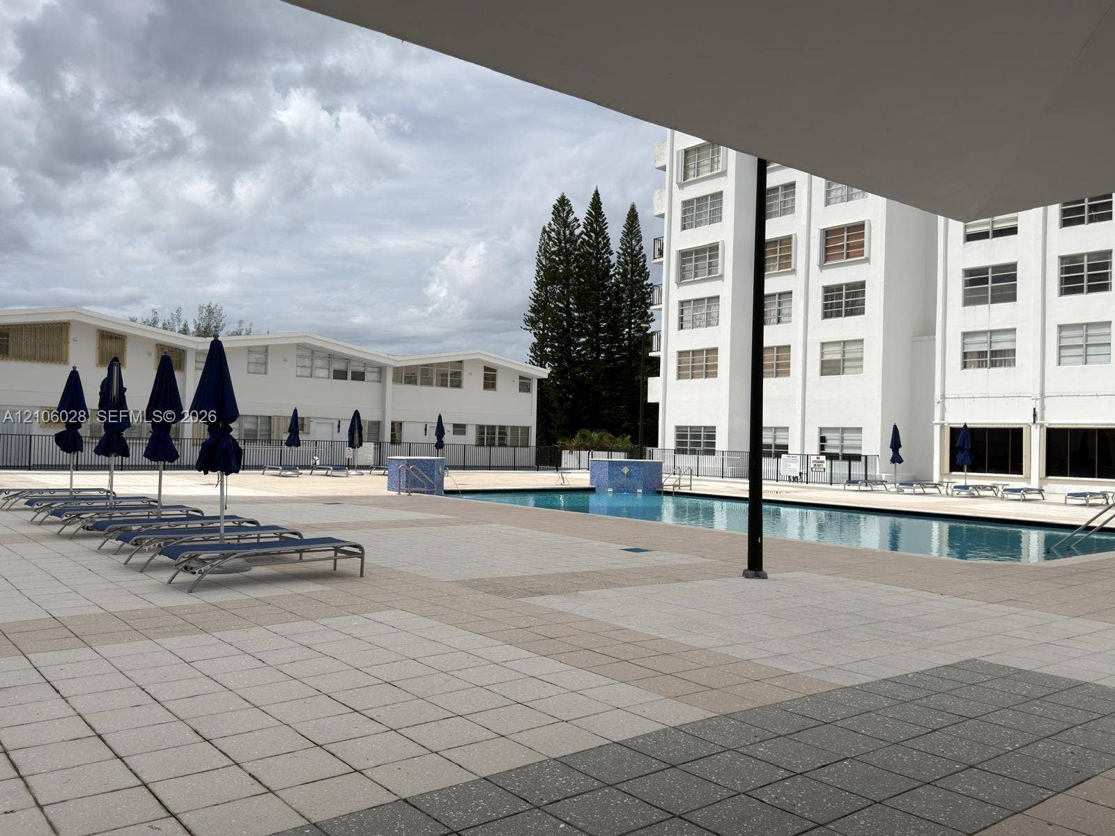 2780 NE 183rd Street, #1605, Aventura, FL 33160 Outdoor swimming pool area featuring a rectangular basin with tile deck surround and metal perimeter fencing