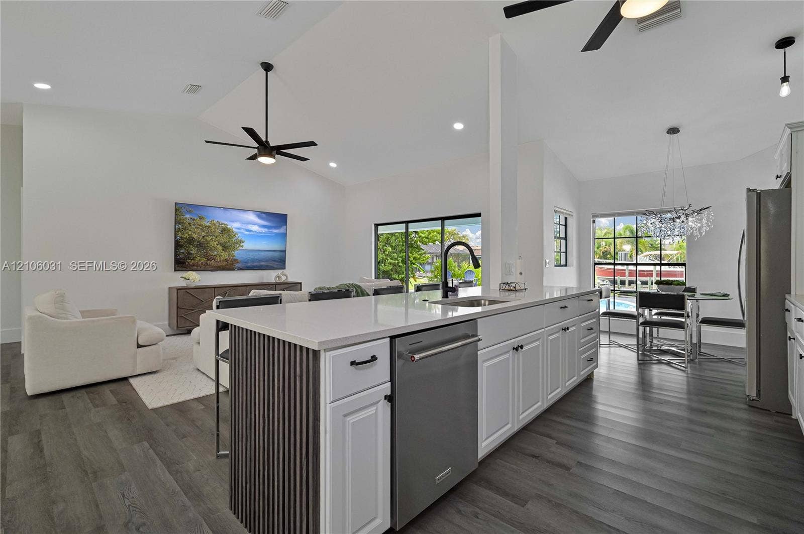 1106 SE 23rd Place, Cape Coral, FL 33990 Kitchen island featuring a stone-surface countertop, slatted wood-finish detailing, stainless steel dishwasher, and matte black hardware