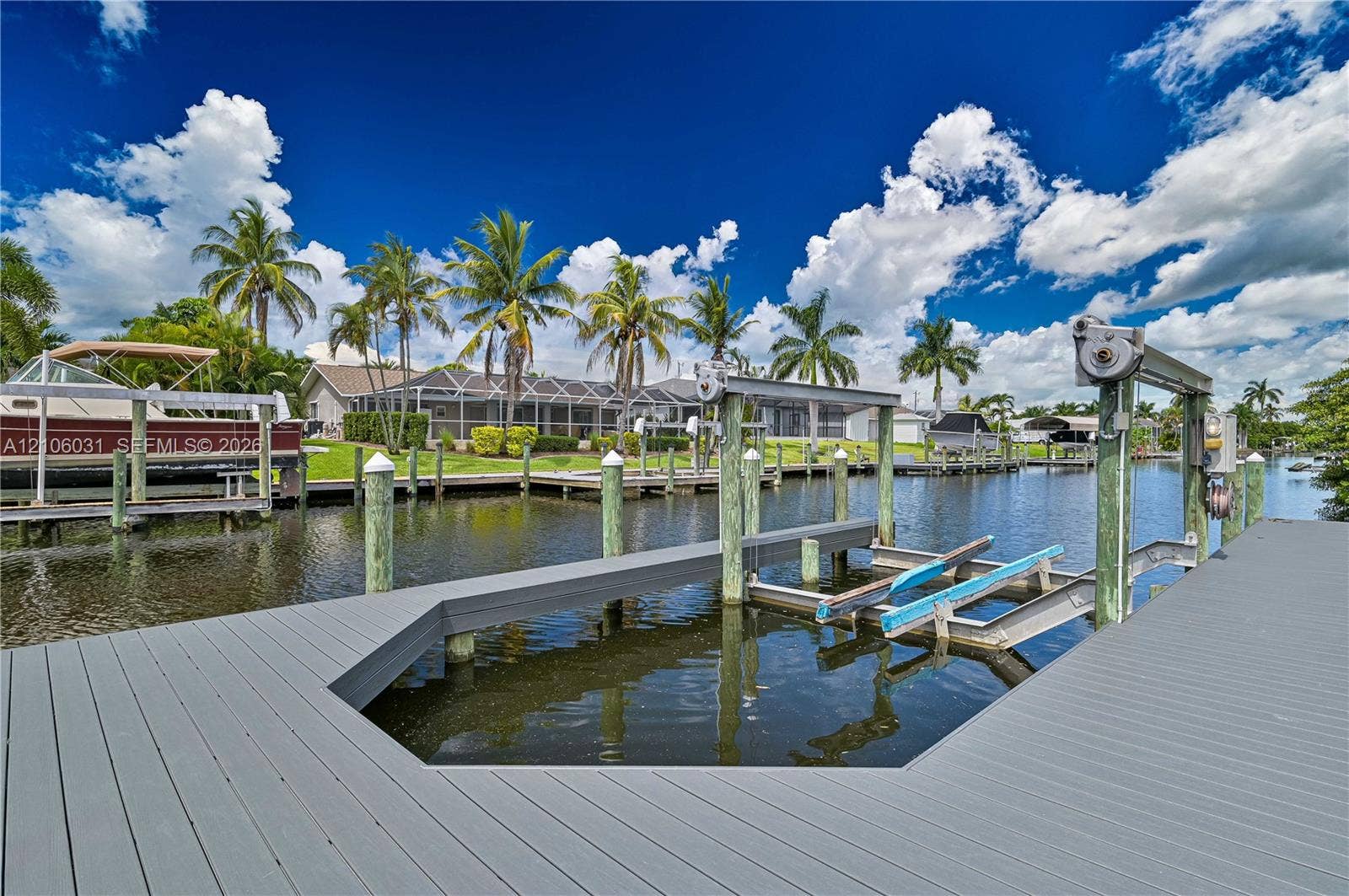 1106 SE 23rd Place, Cape Coral, FL 33990 Private boat dock featuring a heavy-duty mechanical boat lift, composite decking, and direct canal access