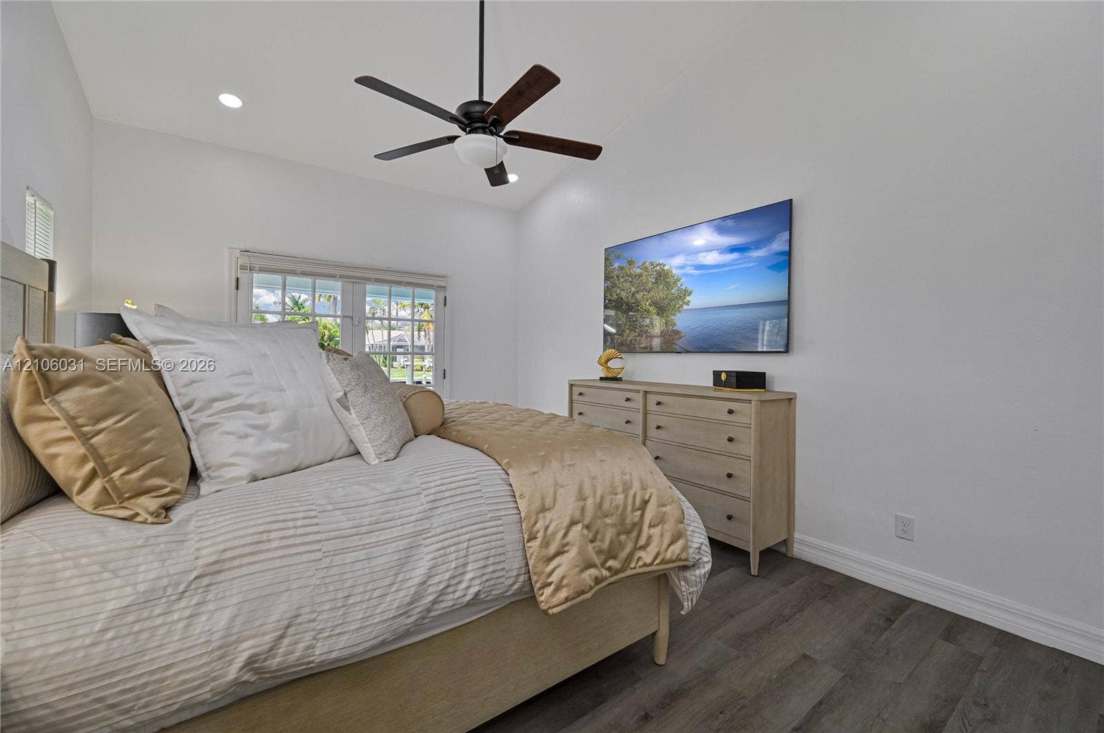 1106 SE 23rd Place, Cape Coral, FL 33990 Vaulted ceiling with integrated recessed lighting, wood-finish flooring, and a multi-blade ceiling fan