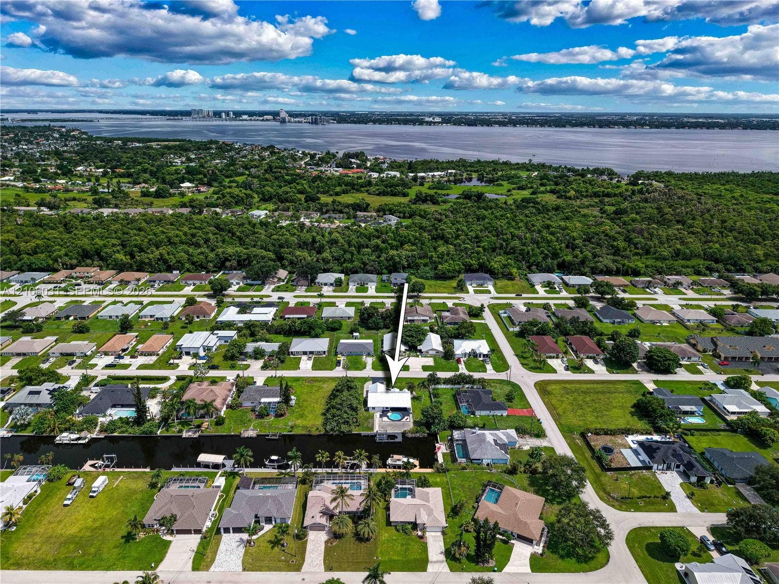 1106 SE 23rd Place, Cape Coral, FL 33990 Aerial perspective of a waterfront property featuring a canal-front lot, a private swimming pool, and a bulkhead