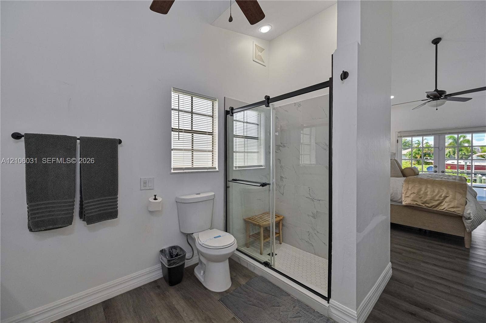 1106 SE 23rd Place, Cape Coral, FL 33990 Walk-in shower featuring a frameless glass enclosure, matte black hardware, and stone-finish wall tile