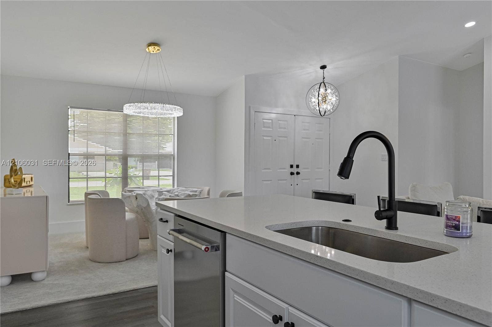 1106 SE 23rd Place, Cape Coral, FL 33990 Kitchen island featuring solid surface countertops, an undermount stainless steel sink, and a matte black gooseneck faucet