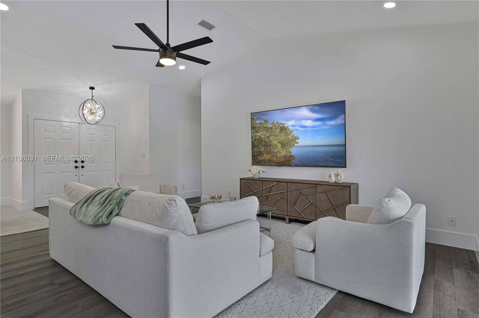 1106 SE 23rd Place, Cape Coral, FL 33990 Vaulted ceilings, wood-finish flooring, multi-blade ceiling fan, orb-style pendant lighting, and double-door entry
