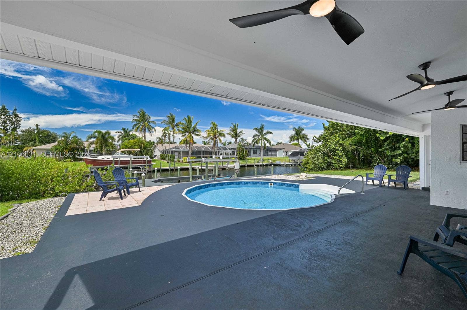 1106 SE 23rd Place, Cape Coral, FL 33990 Covered outdoor patio featuring multiple ceiling fans, circular in-ground pool, and direct bulkhead waterfront access