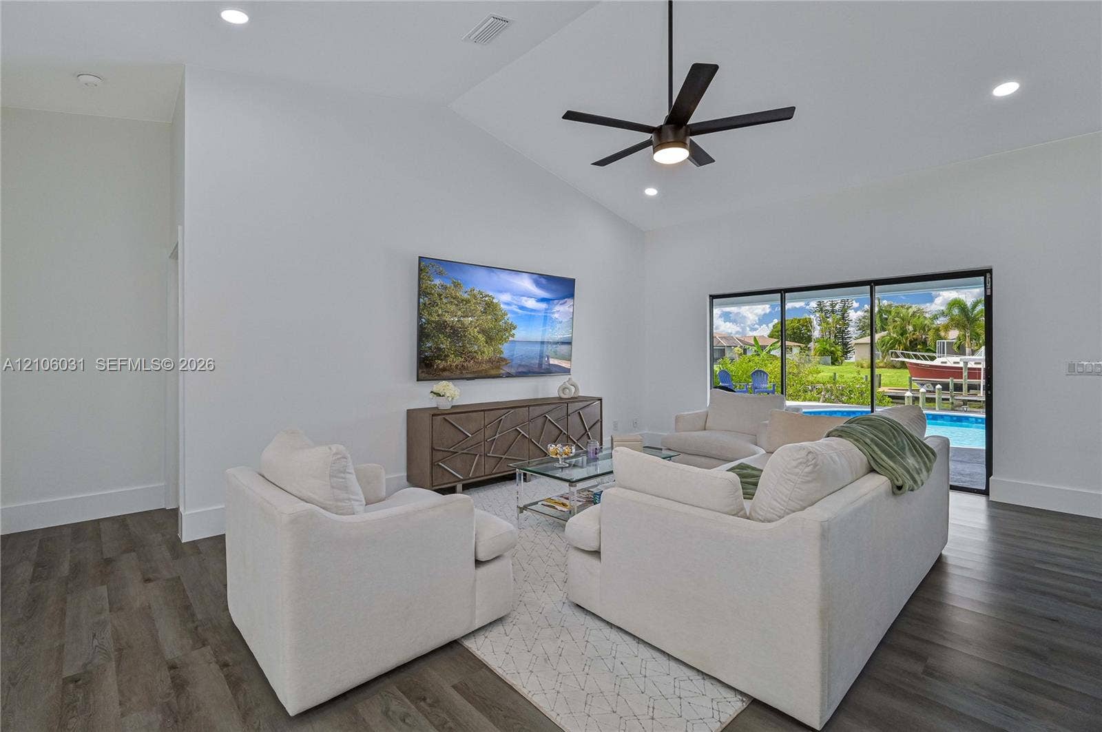 1106 SE 23rd Place, Cape Coral, FL 33990 Vaulted ceilings, wood-finish flooring, recessed lighting, ceiling fan, and sliding glass doors
