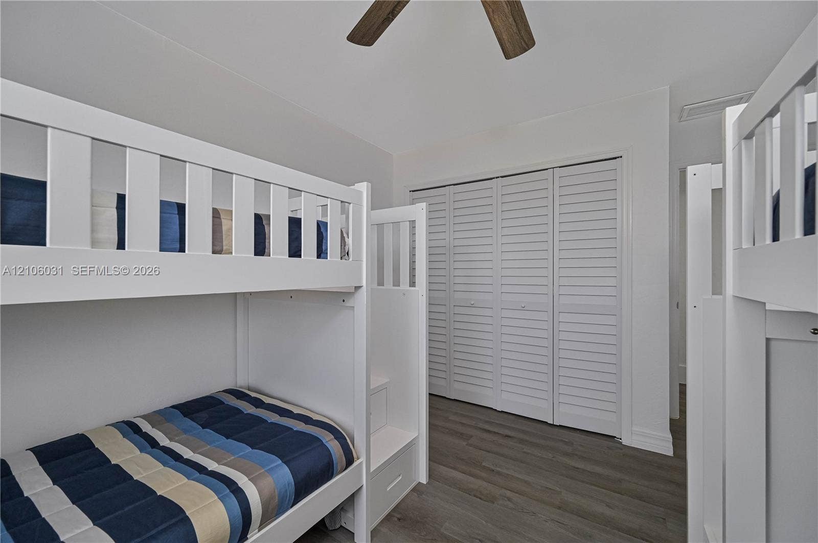 1106 SE 23rd Place, Cape Coral, FL 33990 Wood-finish flooring, white louvered closet doors, and a ceiling fan