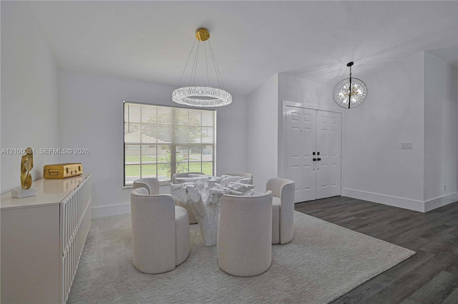 1106 SE 23rd Place, Cape Coral, FL 33990 Dual-tone interior featuring wood-finish flooring, a contemporary crystal ring chandelier, a spherical pendant light, multi-pane window, and double-entry doors