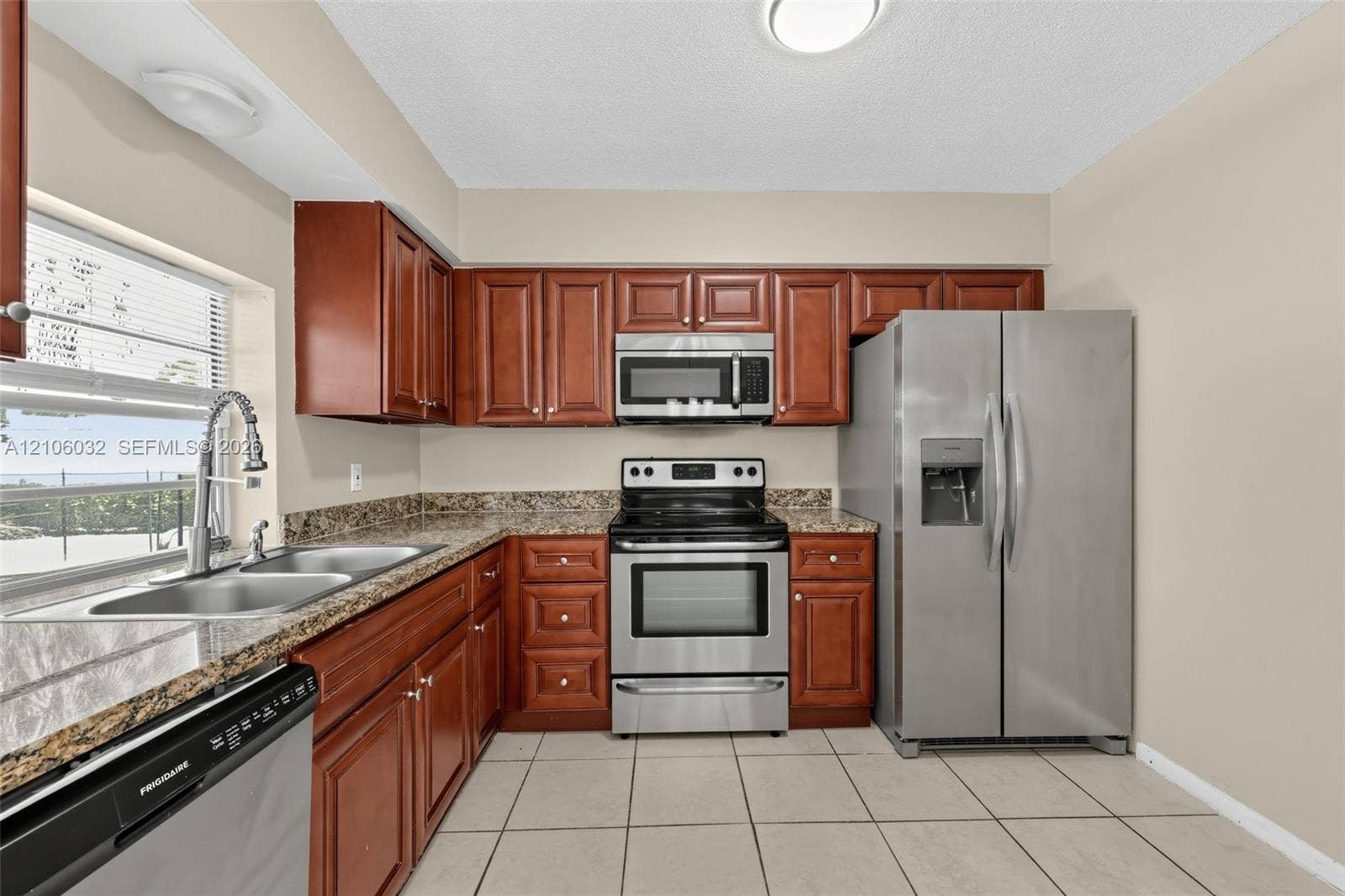 759 NW 7th Street, Boca Raton, FL 33486 Kitchen featuring stained wood cabinetry, stone-finish countertops, stainless steel appliances, and ceramic tile flooring
