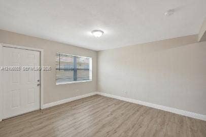 1471 NW 22nd Court, #2, Fort Lauderdale, Fort Lauderdale, FL 33311 Neutral interior featuring wood-finish flooring, a single-panel window, and a white interior door