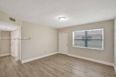1471 NW 22nd Court, #2, Fort Lauderdale, Fort Lauderdale, FL 33311 Interior space featuring wood-finish flooring, a multi-pane horizontal window, neutral wall paint, a flush-mount ceiling light, and interior paneled doors