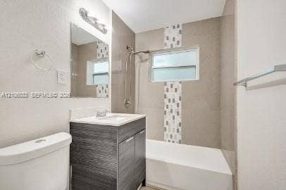 1471 NW 22nd Court, #2, Fort Lauderdale, Fort Lauderdale, FL 33311 Bathroom featuring a dark wood-finish vanity with a white countertop, wall-mounted mirror, soaking tub with a tiled surround, and decorative accent tile inlay
