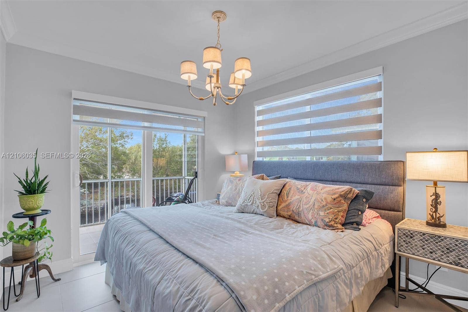 128 Dove Avenue, Tavernier, FL 33070 Neutral-toned interior featuring crown molding, large-format tile flooring, five-light chandelier, and glass sliding doors providing external access