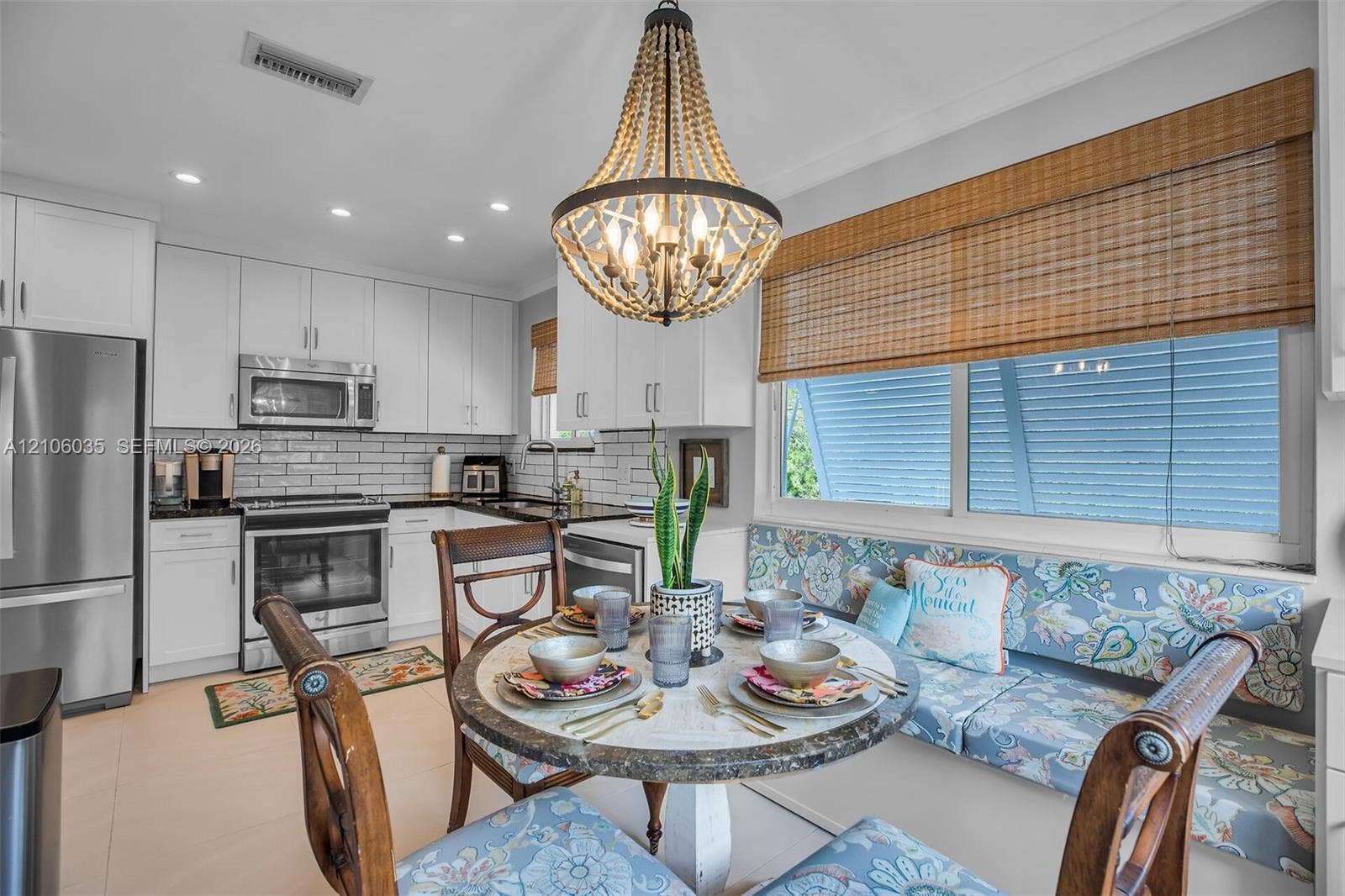 128 Dove Avenue, Tavernier, FL 33070 Kitchen featuring white shaker-style cabinetry, stainless steel appliances, subway tile backsplash, recessed lighting, and a built-in banquette seating area