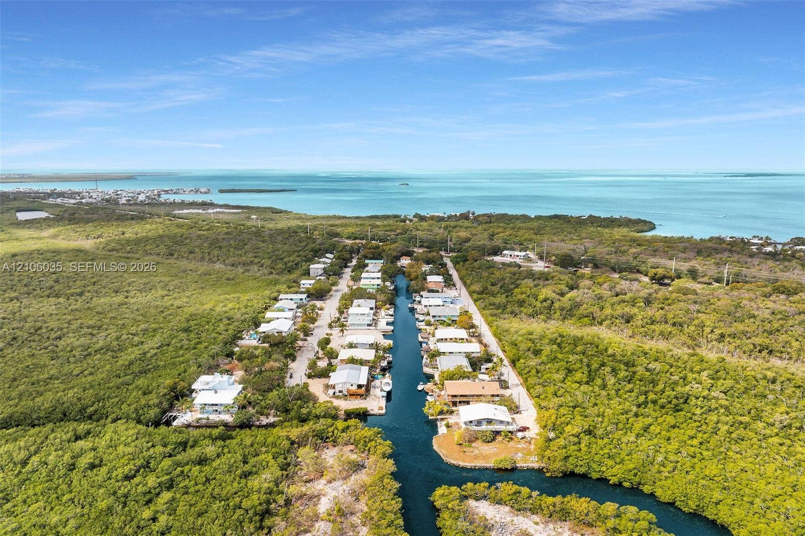 128 Dove Avenue, Tavernier, FL 33070 Aerial perspective of a coastal residential community featuring direct canal access, deep-water frontage, and immediate proximity to the open ocean