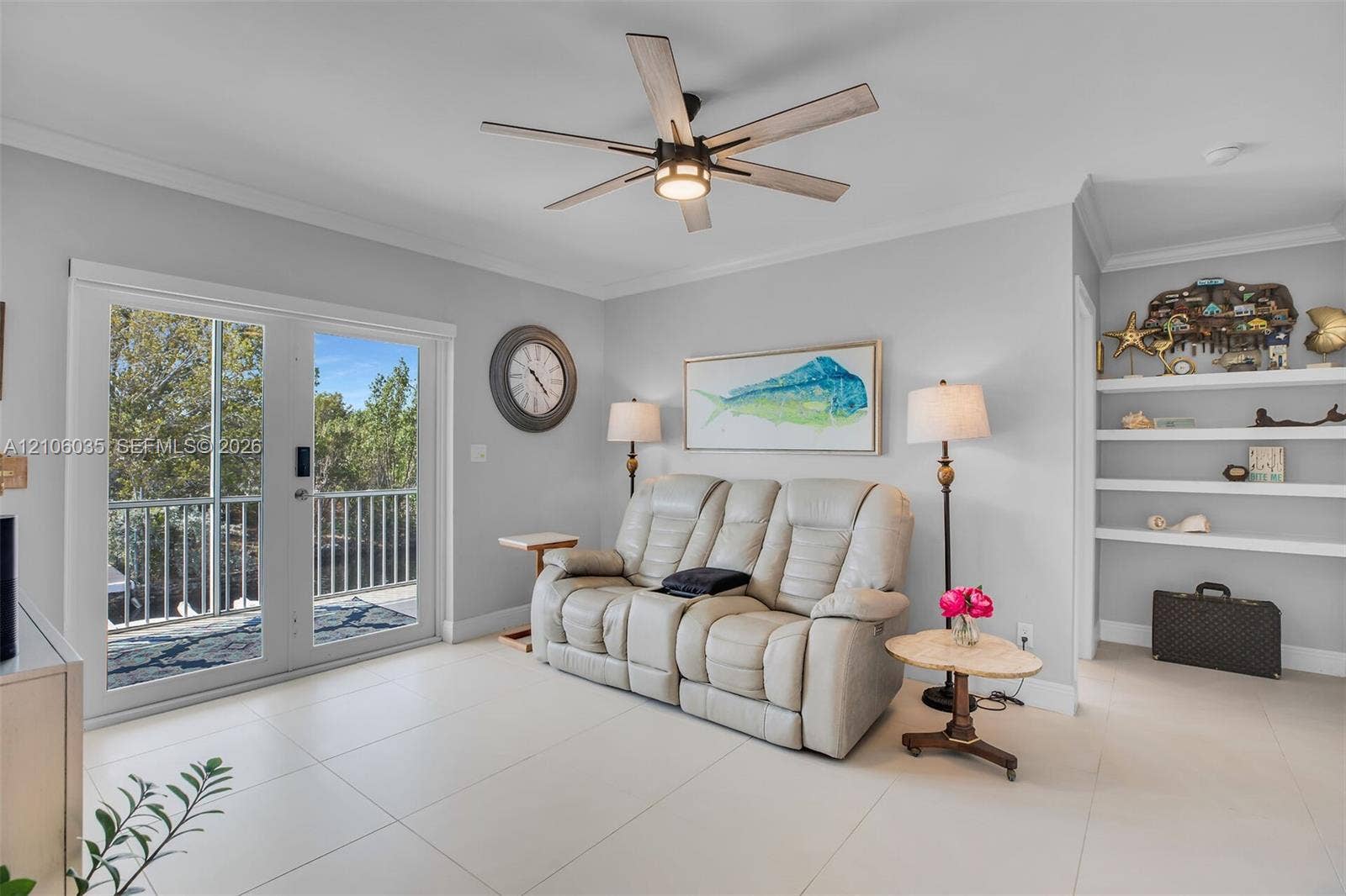 128 Dove Avenue, Tavernier, FL 33070 Large-format tile flooring, double glass door with integrated railing, contemporary ceiling fan with light fixture, and built-in wall shelving