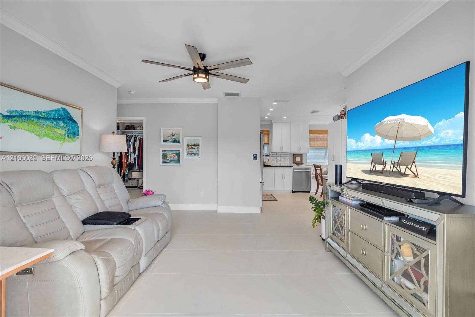 128 Dove Avenue, Tavernier, FL 33070 Open living area featuring large-format tile flooring, crown molding, and a modern multi-blade ceiling fan with integrated lighting
