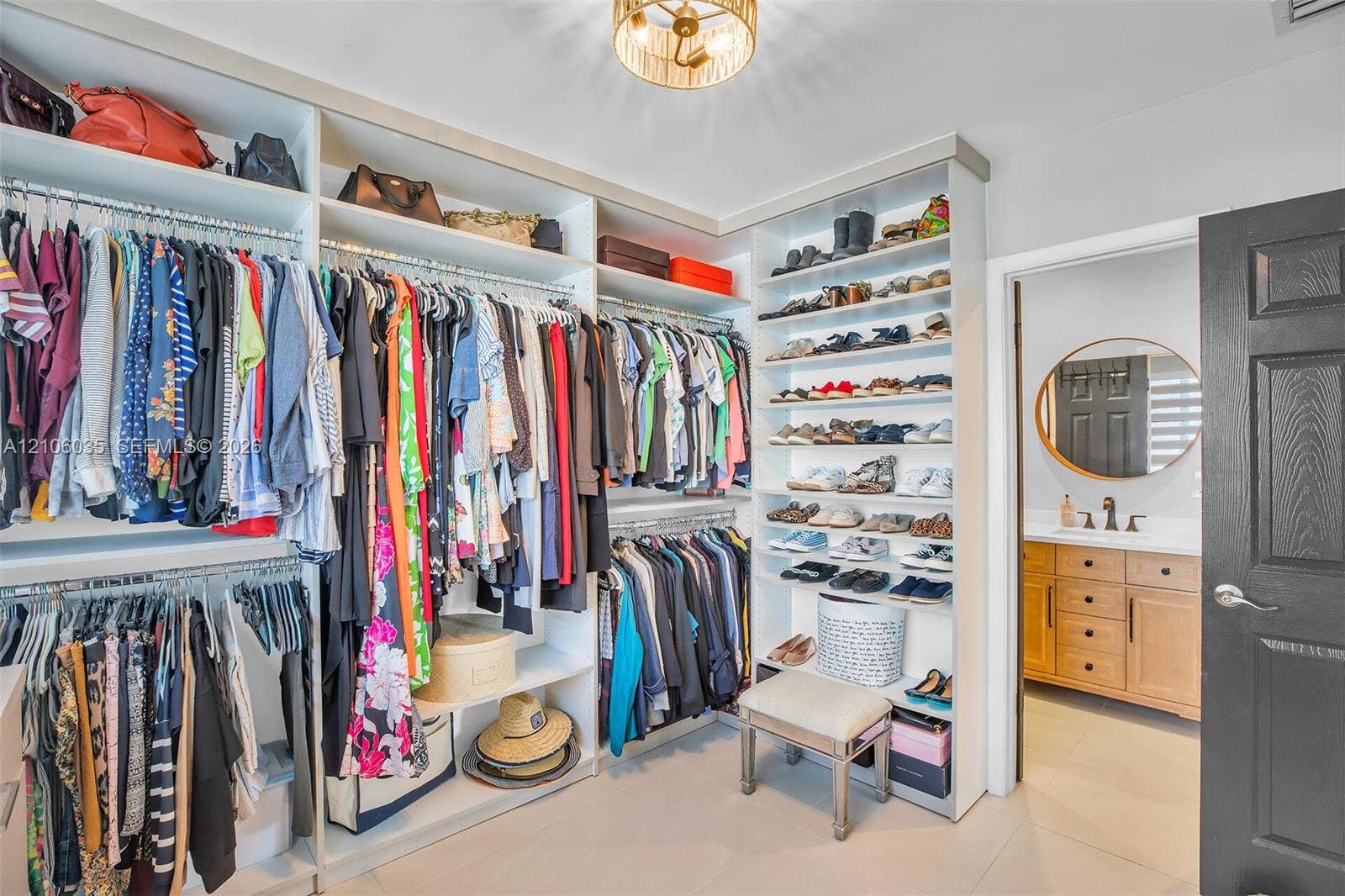 128 Dove Avenue, Tavernier, FL 33070 Custom built-in closet organization system with floor-to-ceiling shelving, tiered hanging rods, light-finish cabinetry, and a flush-mount drum ceiling fixture