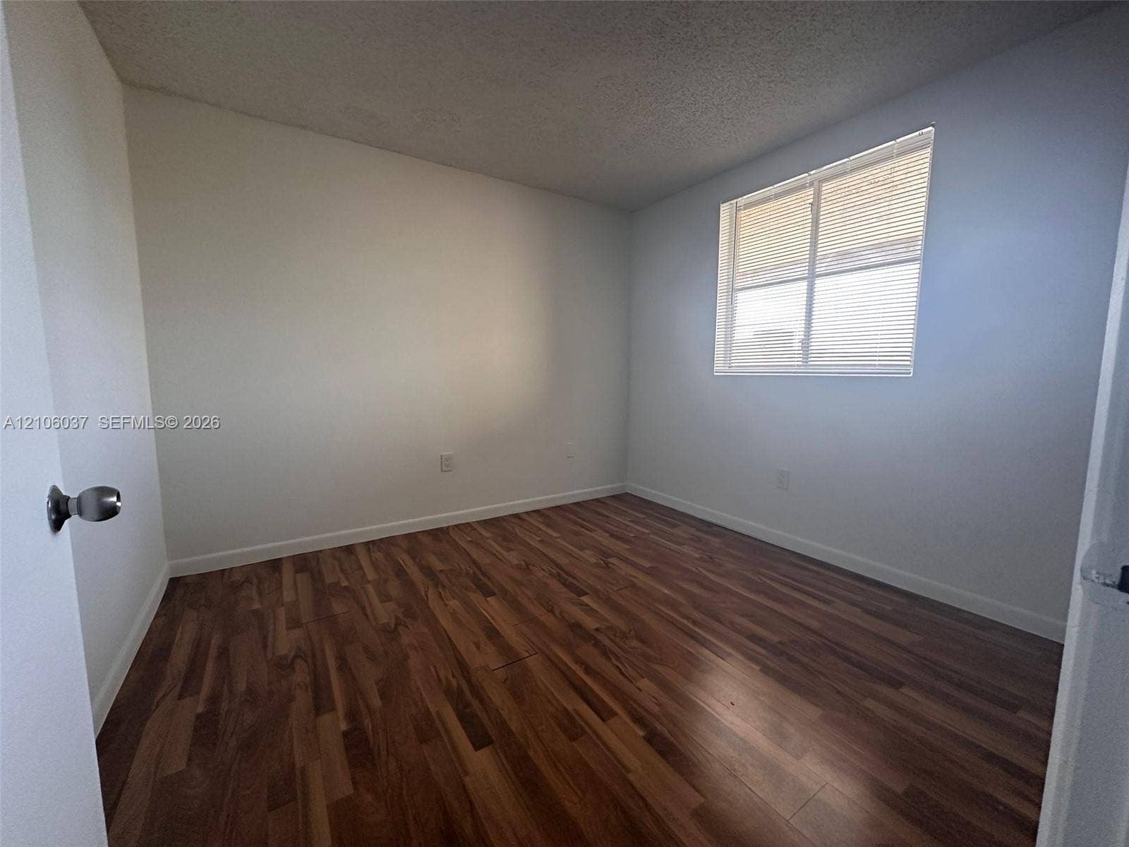 14951 SW 82nd Lane, #17-504, Miami, FL 33193 Wood-finish flooring, neutral wall tones, and single-pane window with horizontal blinds
