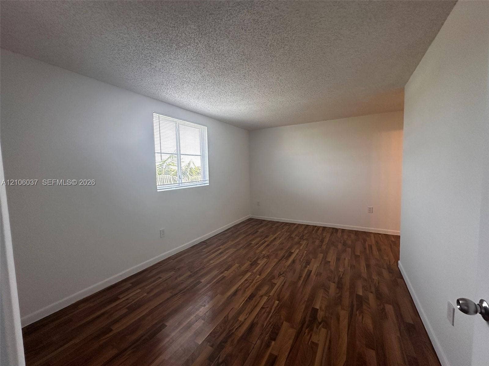 14951 SW 82nd Lane, #17-504, Miami, FL 33193 Interior space featuring wood-finish flooring, white walls, and a single-pane window with integrated blinds
