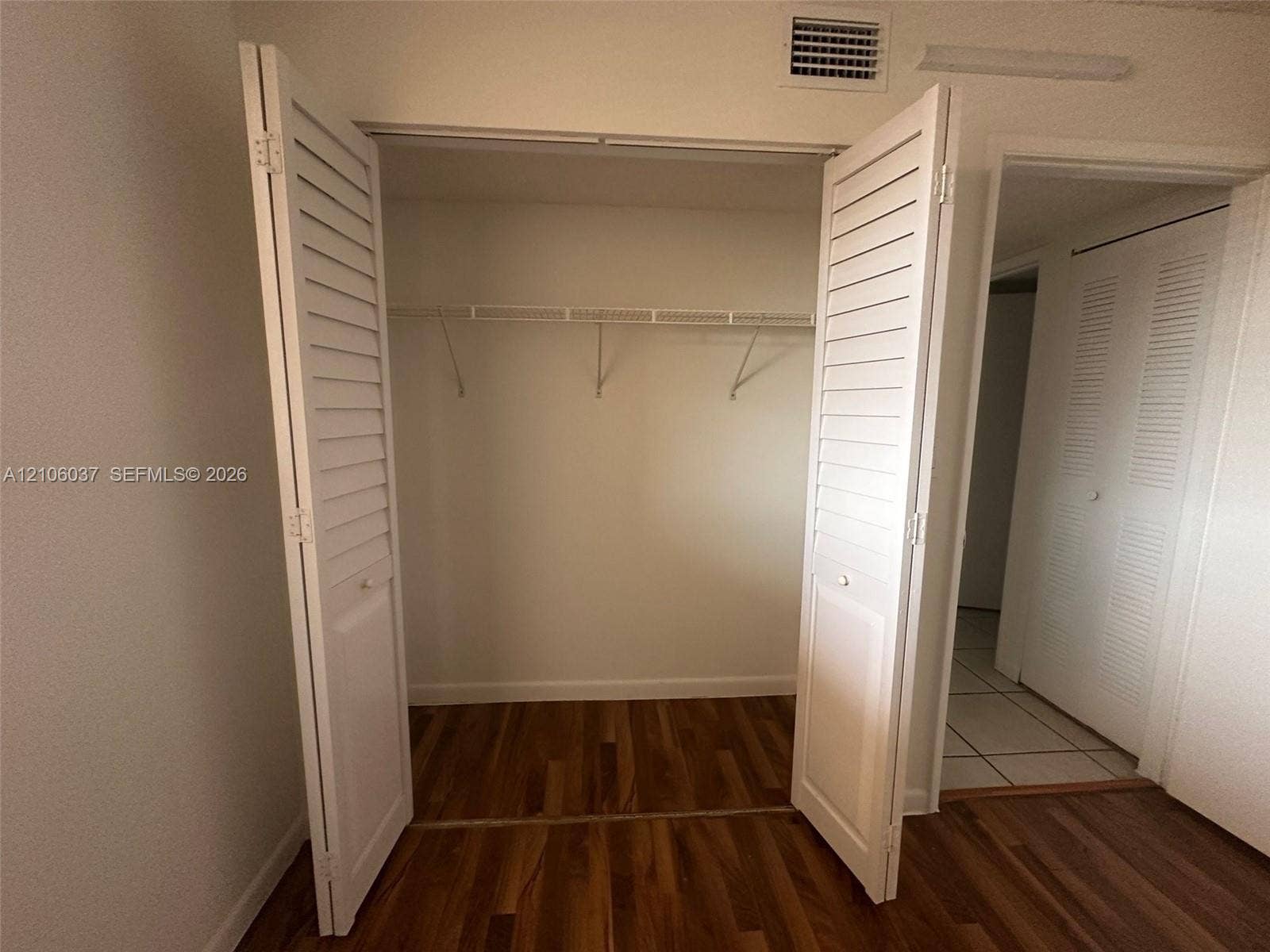 14951 SW 82nd Lane, #17-504, Miami, FL 33193 Closet featuring white louvered bifold doors, wood-finish flooring, and integrated wire shelving