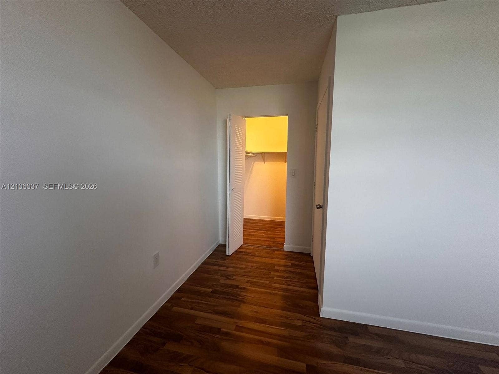 14951 SW 82nd Lane, #17-504, Miami, FL 33193 Wood-finish flooring, neutral walls, and a walk-in closet with built-in shelving