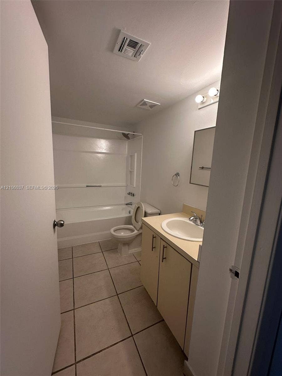 14951 SW 82nd Lane, #17-504, Miami, FL 33193 Bathroom featuring ceramic tile flooring, a single-sink vanity with a solid-surface countertop, and a tub-shower combination with a surround
