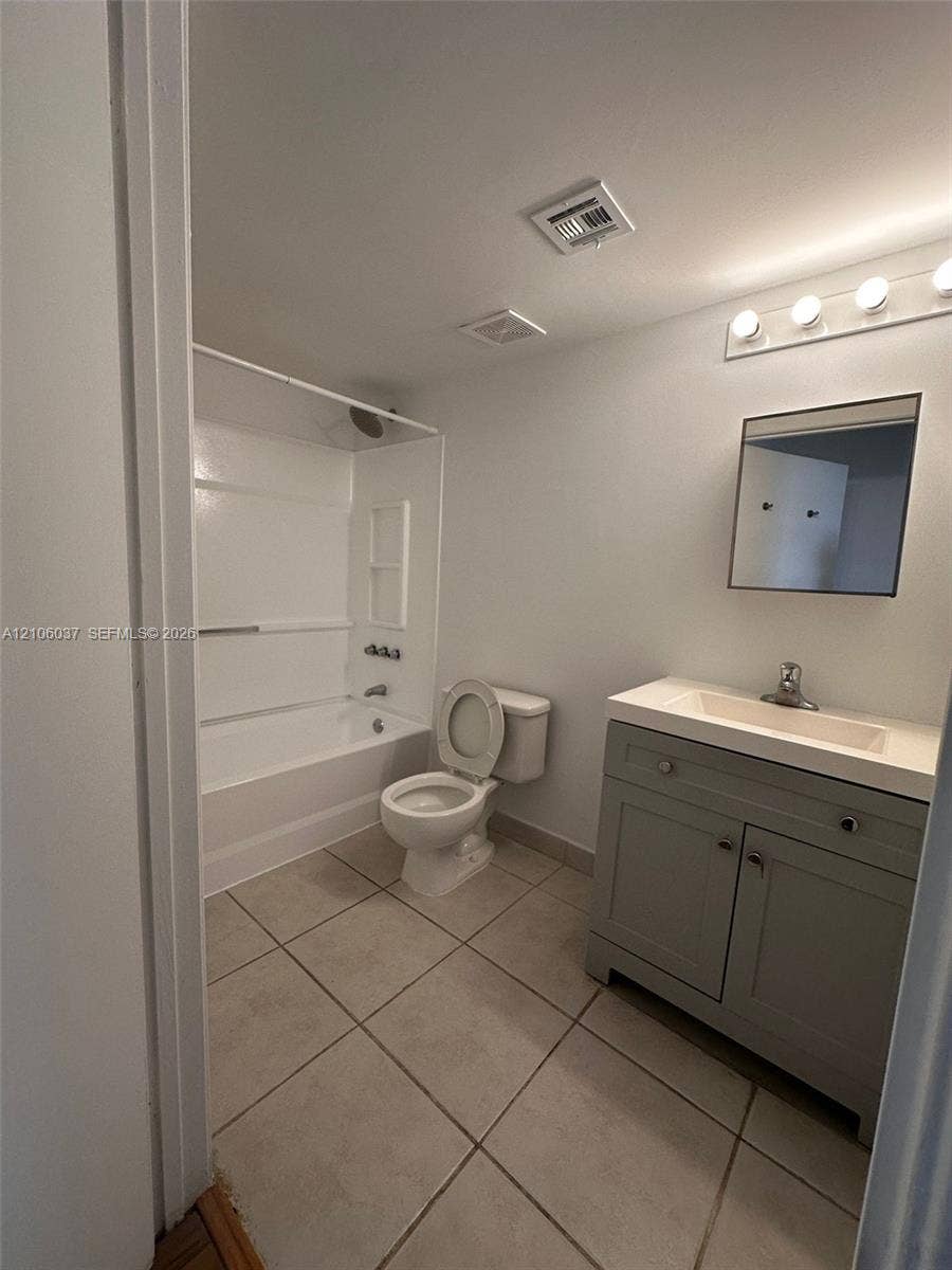 14951 SW 82nd Lane, #17-504, Miami, FL 33193 Spacious bathroom featuring ceramic tile flooring, a vanity with cabinet storage and integrated sink, a toilet, and a bathtub/shower combination with surround enclosure