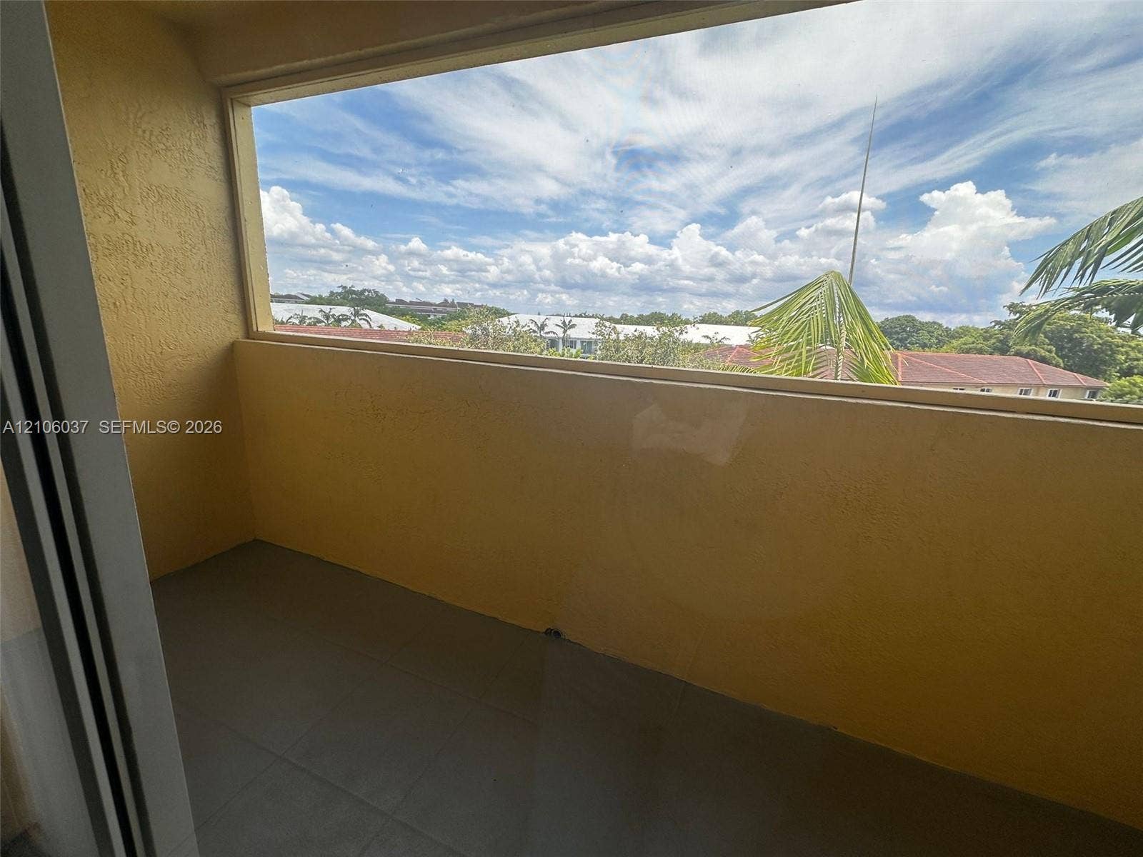 14951 SW 82nd Lane, #17-504, Miami, FL 33193 Covered balcony featuring concrete flooring, textured walls, and a large window enclosure