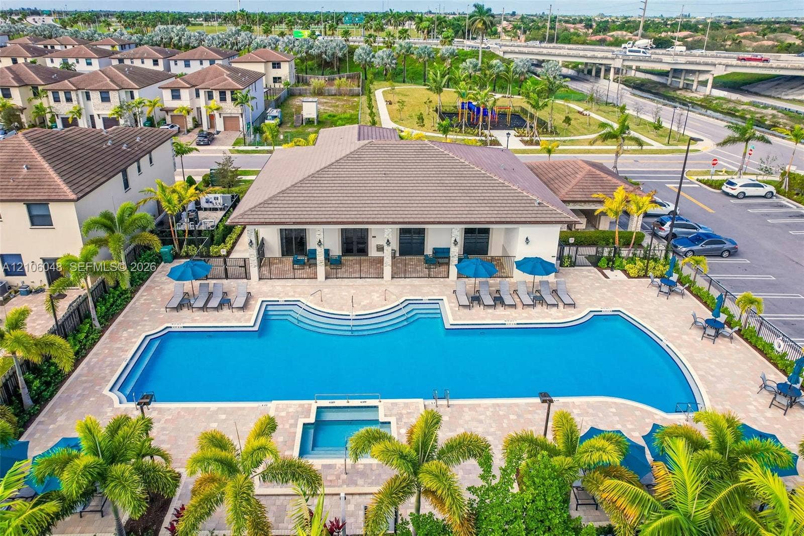 25134 SW 108th Court, Homestead, FL 33032 Resort-style resort amenity featuring a resort-style zero-entry pool with curved architectural design, spa, and integrated sun shelf