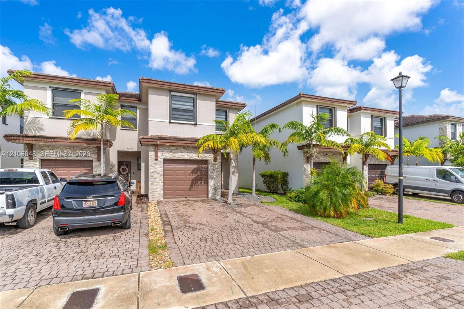 25134 SW 108th Court, Homestead, FL 33032 Two-story exterior featuring a stone veneer facade, paver driveway, integrated garage, and low-slope roof