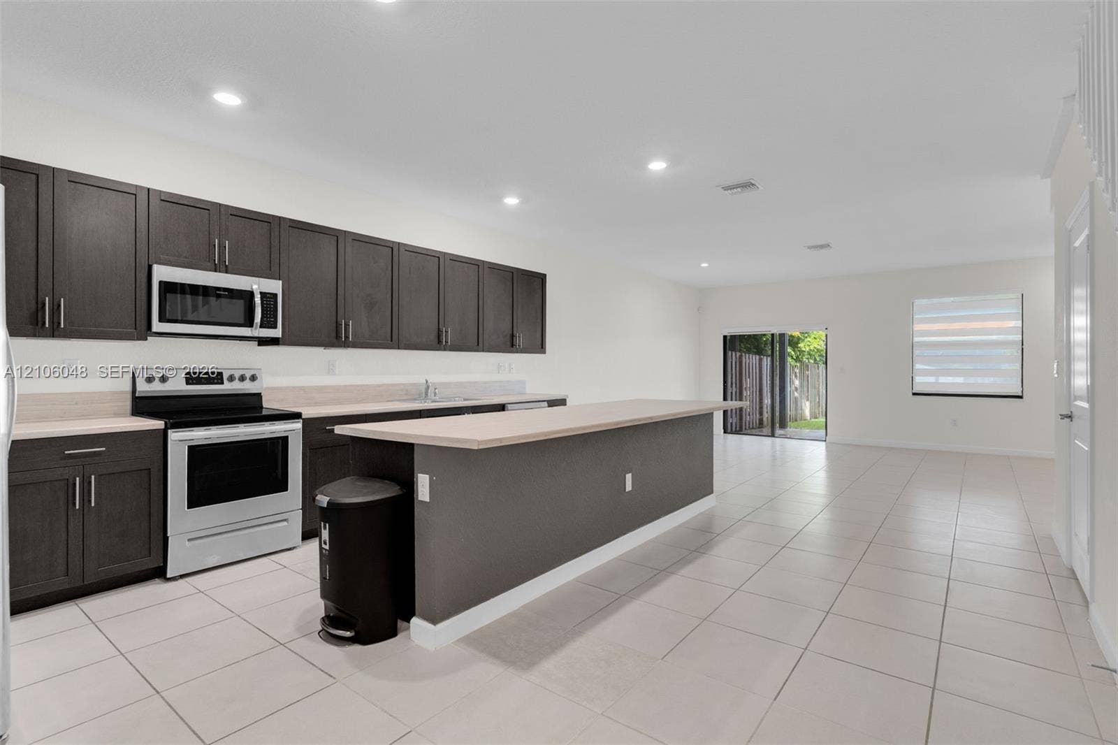25134 SW 108th Court, Homestead, FL 33032 Kitchen featuring dark cabinetry, expansive breakfast bar, recessed lighting, and tile flooring