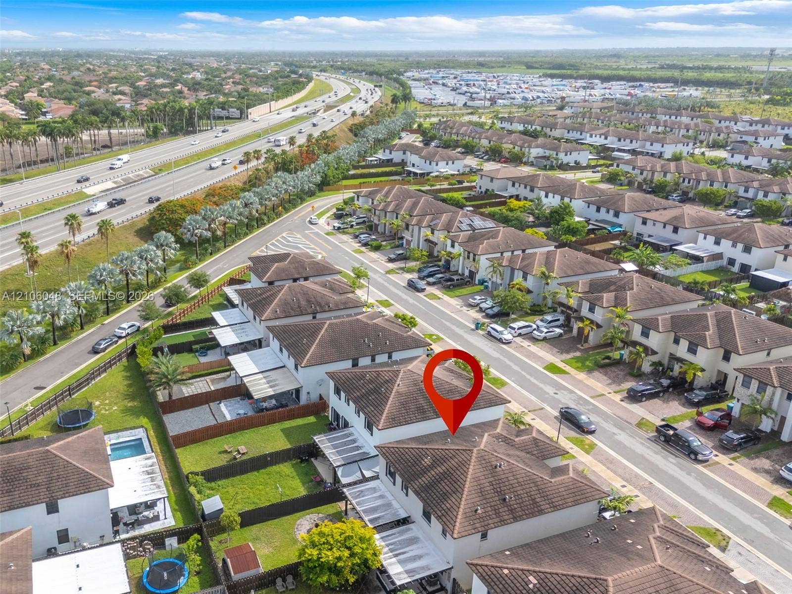 25134 SW 108th Court, Homestead, FL 33032 Aerial perspective featuring a two-story residence with a tiled roof, private fenced-in backyard, and hardscaped patio