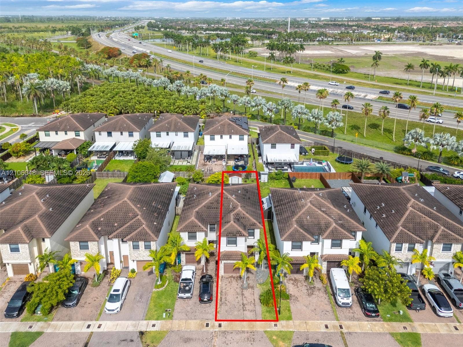 25134 SW 108th Court, Homestead, FL 33032 Two-story residential property featuring a tiled roof, paved driveway, and established palm tree landscaping