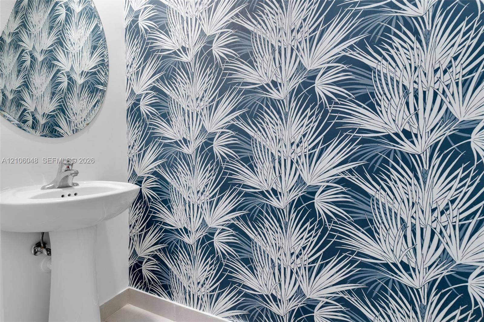 25134 SW 108th Court, Homestead, FL 33032 Botanical-print wallpaper, pedestal sink with polished chrome hardware, and circular wall mirror