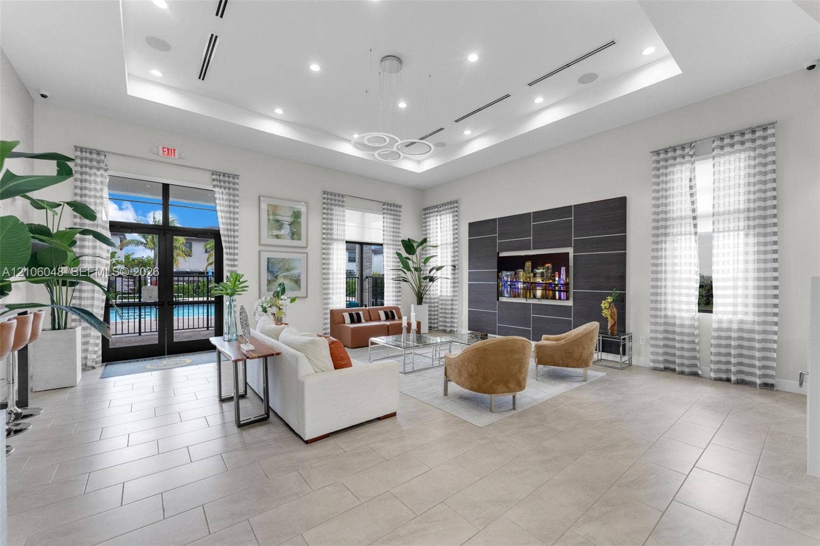 25134 SW 108th Court, Homestead, FL 33032 Tray ceiling with recessed lighting, large-format tile flooring, oversized windows, and a structured panel wall feature