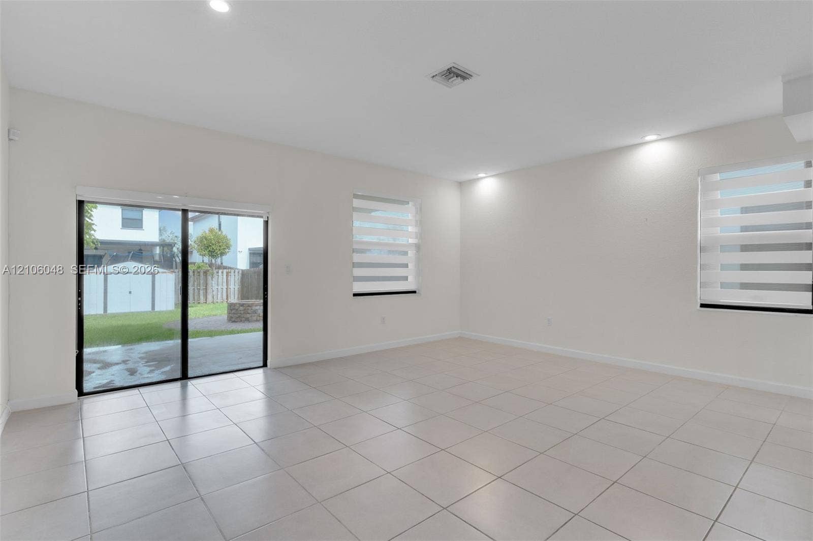 25134 SW 108th Court, Homestead, FL 33032 Open living area featuring large-format tile flooring, recessed lighting, and horizontal shade window coverings