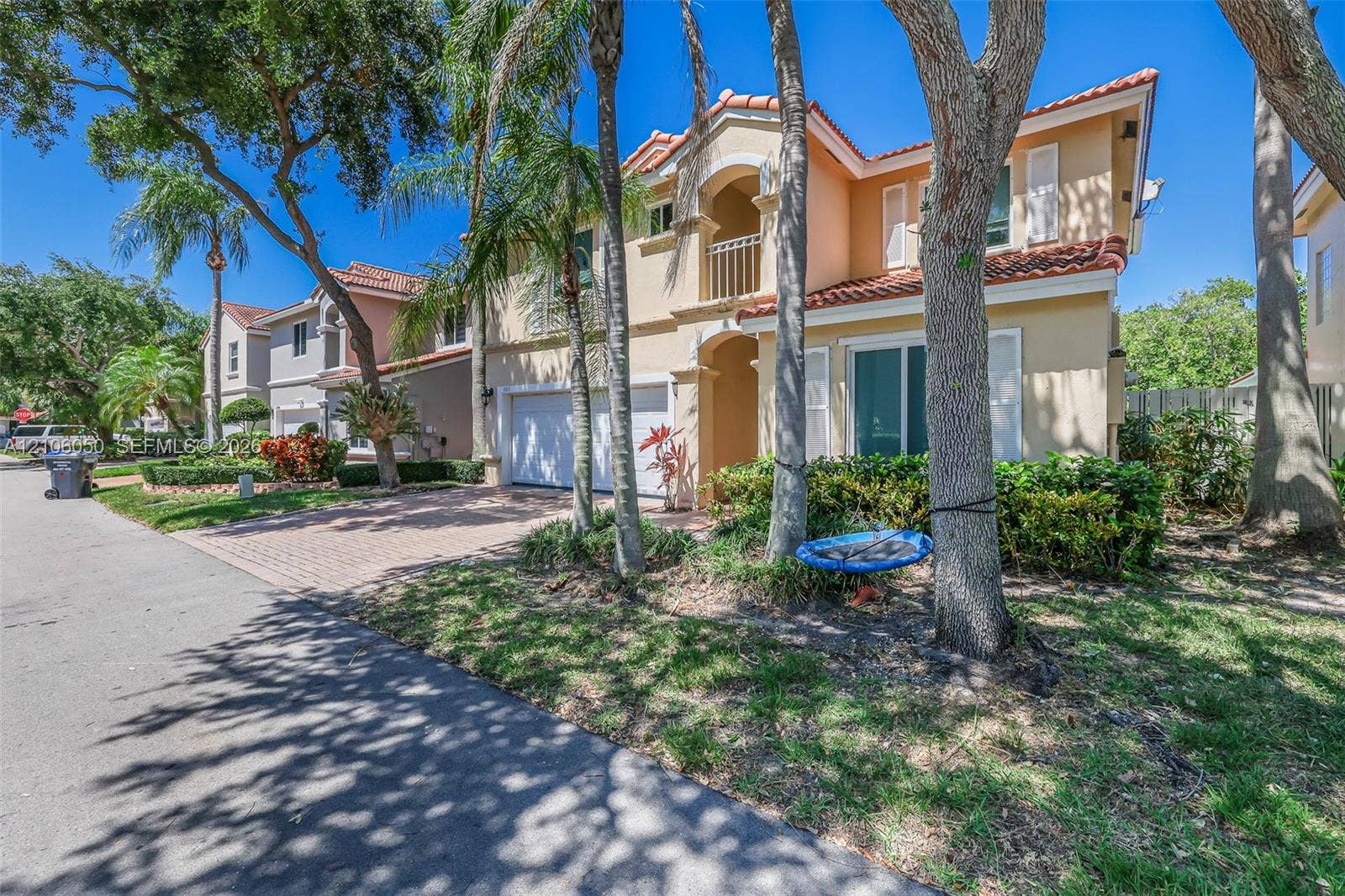 1065 Weeping Willow Way, #0, Hollywood, Hollywood, FL 33019 Stucco exterior featuring a red tile roof, two-story architectural design, brick-paver driveway, and an upper-level balcony