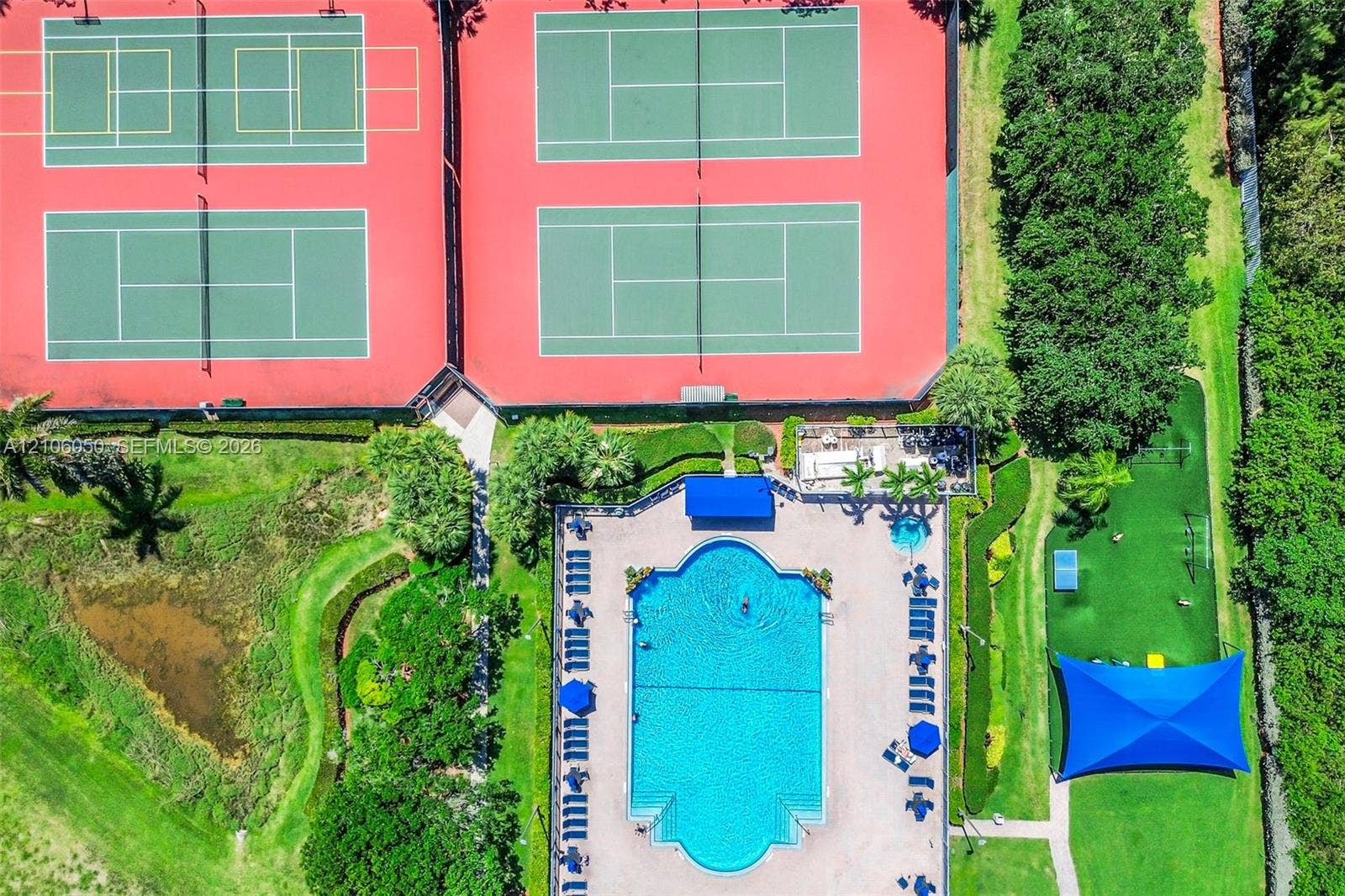 1065 Weeping Willow Way, #0, Hollywood, Hollywood, FL 33019 Recreational complex featuring four tennis courts, a swimming pool, a separate spa, and a shaded outdoor area with turf