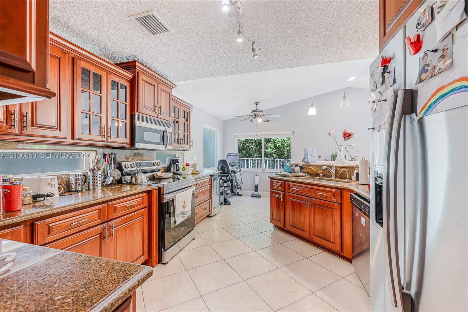 1065 Weeping Willow Way, #0, Hollywood, Hollywood, FL 33019 Kitchen featuring wood cabinetry, stone countertops, stainless steel appliances, ceramic tile flooring, and vaulted ceilings