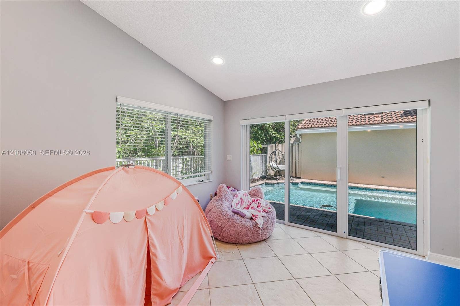 1065 Weeping Willow Way, #0, Hollywood, Hollywood, FL 33019 Vaulted ceiling featuring recessed lighting, large-format tile flooring, and sliding glass doors opening to an exterior swimming pool