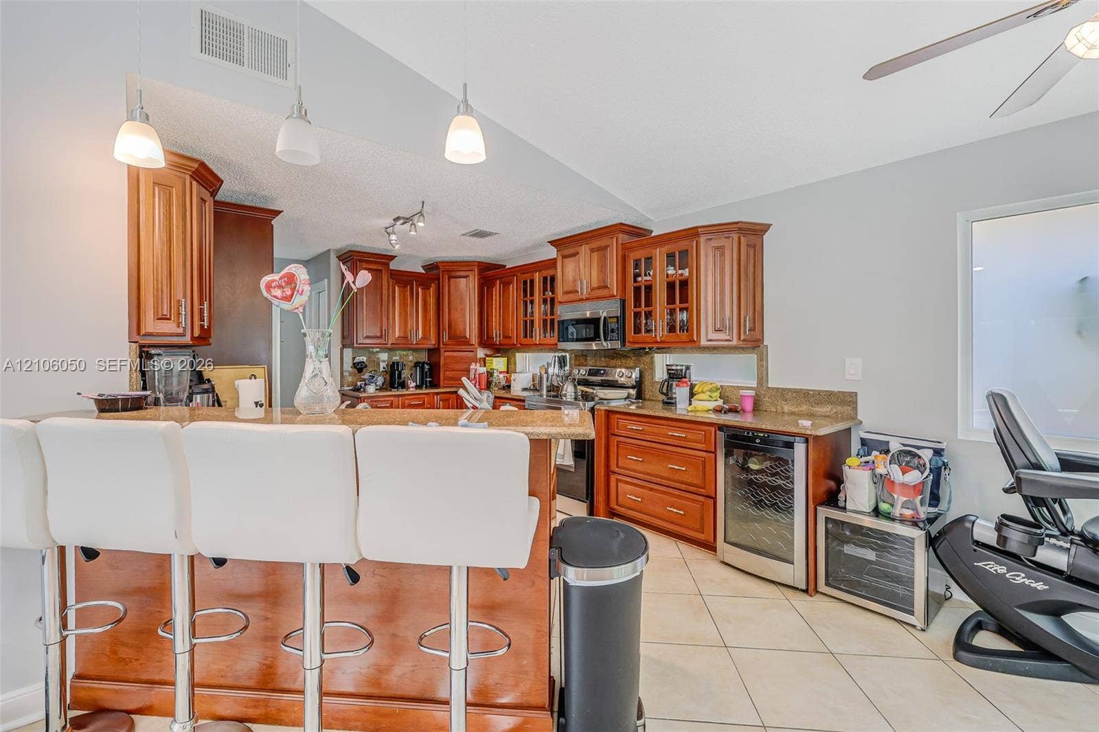 1065 Weeping Willow Way, #0, Hollywood, Hollywood, FL 33019 Kitchen featuring wood cabinetry, stone countertops, breakfast bar, and under-counter beverage refrigerator