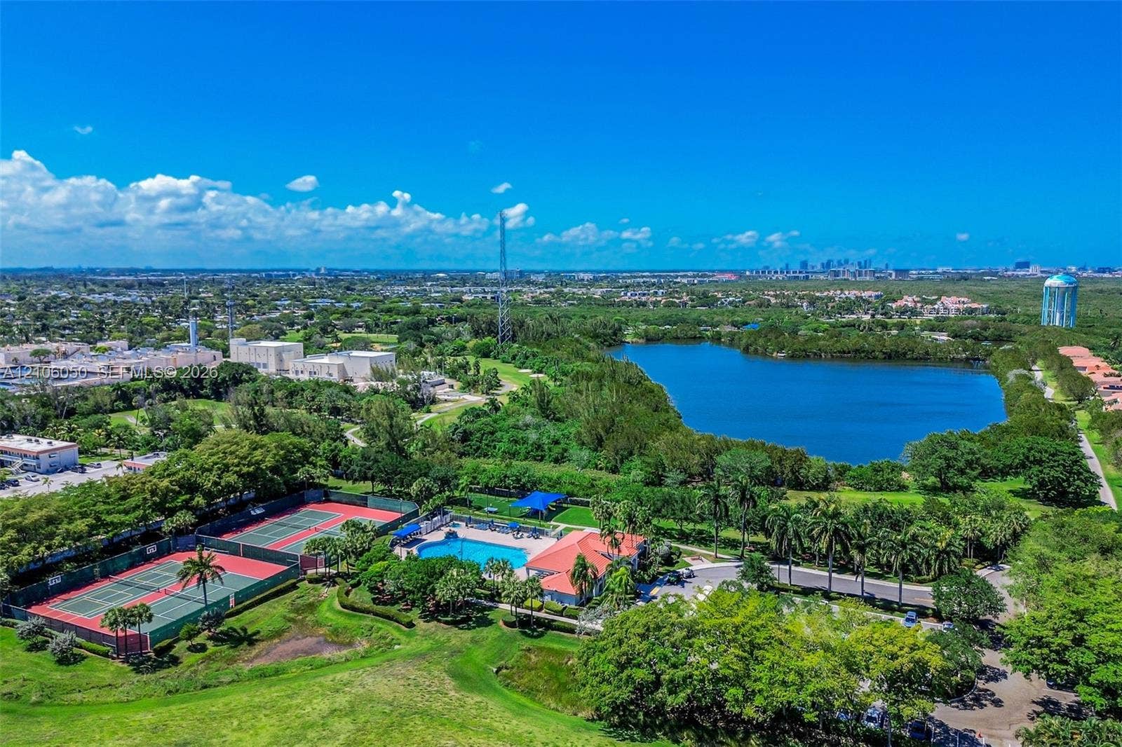 1065 Weeping Willow Way, #0, Hollywood, Hollywood, FL 33019 Aerial perspective featuring a community swimming pool, two hard-court tennis surfaces, and a large lake
