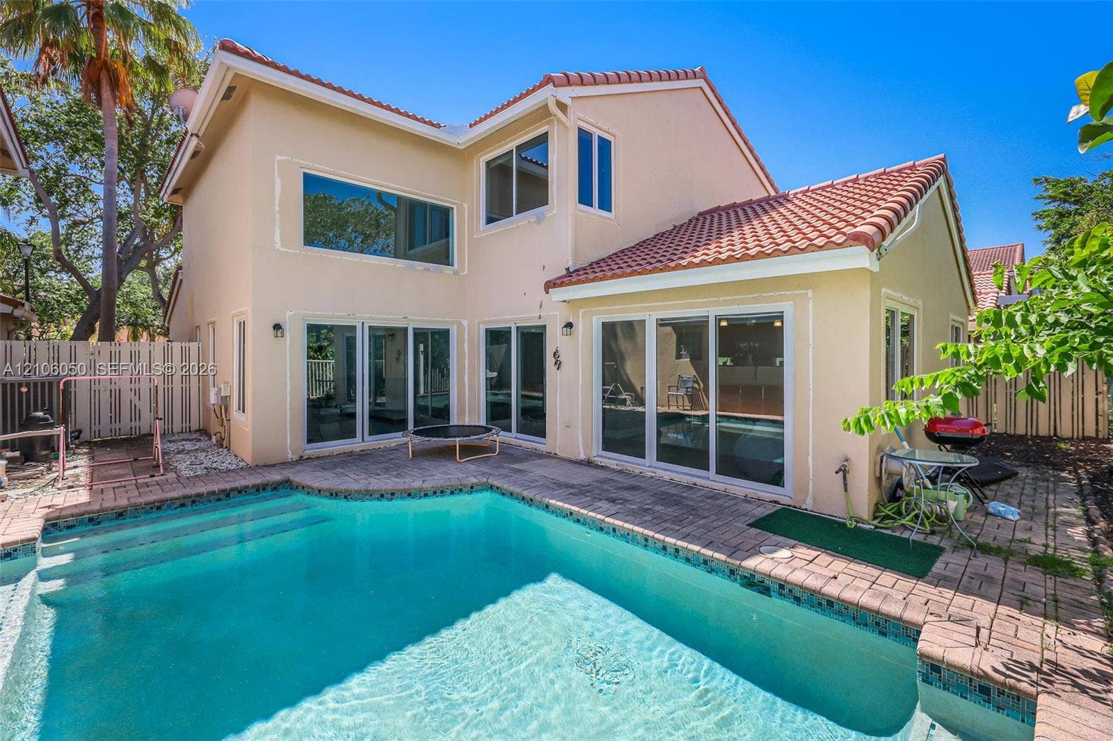 1065 Weeping Willow Way, #0, Hollywood, Hollywood, FL 33019 Two-story stucco exterior featuring a clay tile roof, a swimming pool with integrated stairs, and multi-panel sliding glass doors