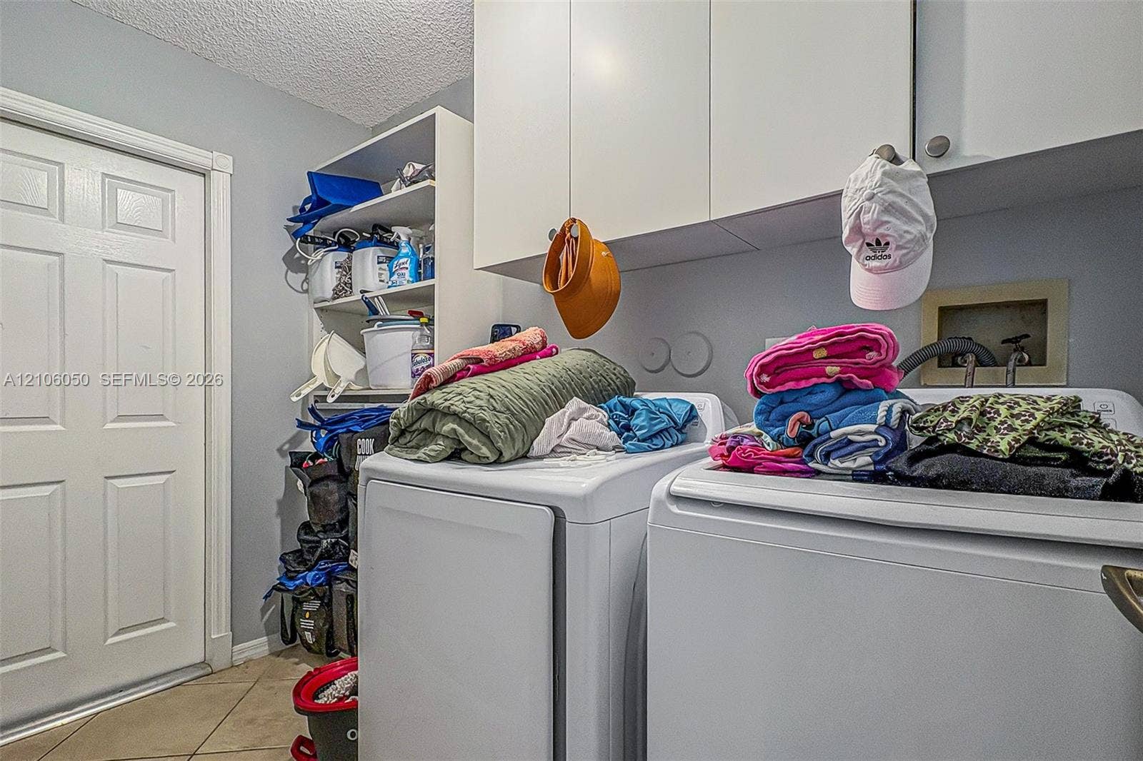 1065 Weeping Willow Way, #0, Hollywood, Hollywood, FL 33019 Laundry room featuring white wall-mounted cabinetry, open shelving, and tile flooring